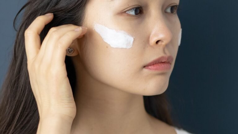 Woman with white sunscreen cream applied on her face